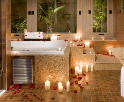 Foto de la bañera para dos personas, decorada con velas y pétalos de rosa del hotel Melia Madrid Princesa