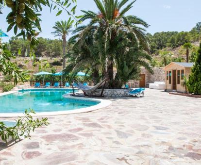 Agradable zona exterior con piscina rodeada de jardines de este hotel con encanto.