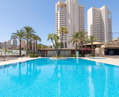 Hotel con encanto con amplia piscina exterior rodeada de tumbonas.