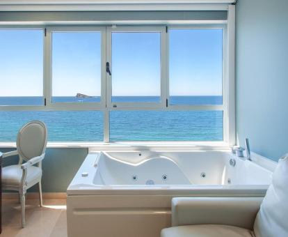 Acogedor rincón de la Habitación Doble con bañera de hidromasaje privada y vistas al mar del hotel.