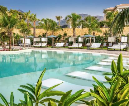 Una de las preciosas piscinas exteriores con tumbonas en el agua y vegetación de este hotel con encanto.