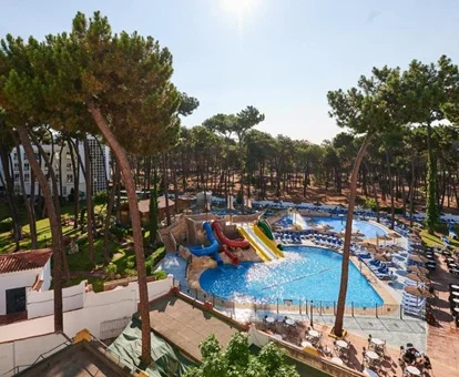 Vista aérea del hotel Alasun Marbella Park donde se ven las piscina con toboganes y los jardines con pinos y cesped