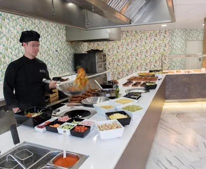 Foto del cocinero en la parte de parrilla en vivo del buffet