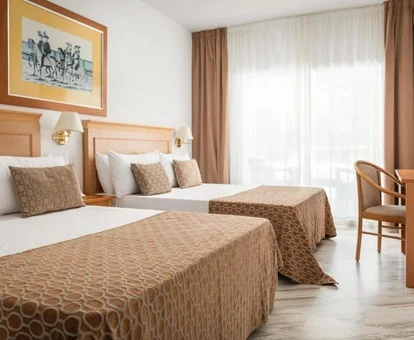 Mesa con unas sillas y dos camas dobles junto a la terraza en la habitación cuádruple