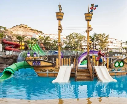 Zona de toboganes en la piscina infantil de baja profundidad donde se puede ver un barco pirata