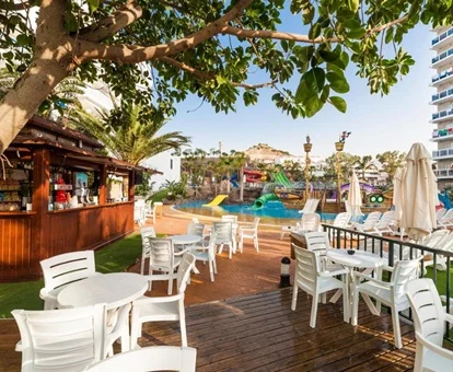 Zona con sillas para tomar algo junto a la piscina en el bar