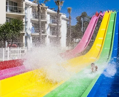 Parte final de cuatro toboganes con unos niños disfrutando en ellos