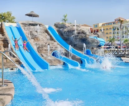 Foto de los cuatro toboganes que dan a la piscina con el hotel Mediterraneo Bay al fondo