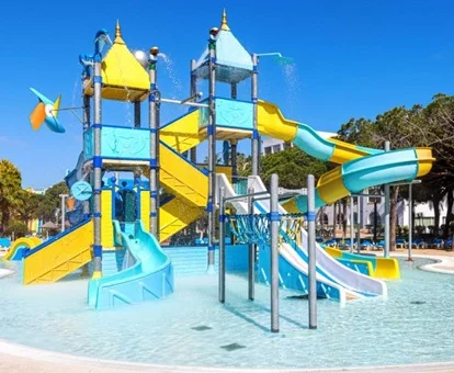 Zona infantil con chorros de agua y toboganes para los más pequeños en la piscina con poca profundidad