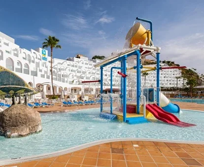 Zona infantil con chorros de agua y toboganes para los más pequeños en la piscina con poca profundidad
