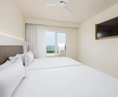 Dos enormes camas en la habitación familiar con vistas al mar y las piscinas del hotel Playamojácar