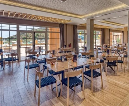 Zona del comedor y cafeteria con vistas a las piscinas del exterior y tambi''en a la playa