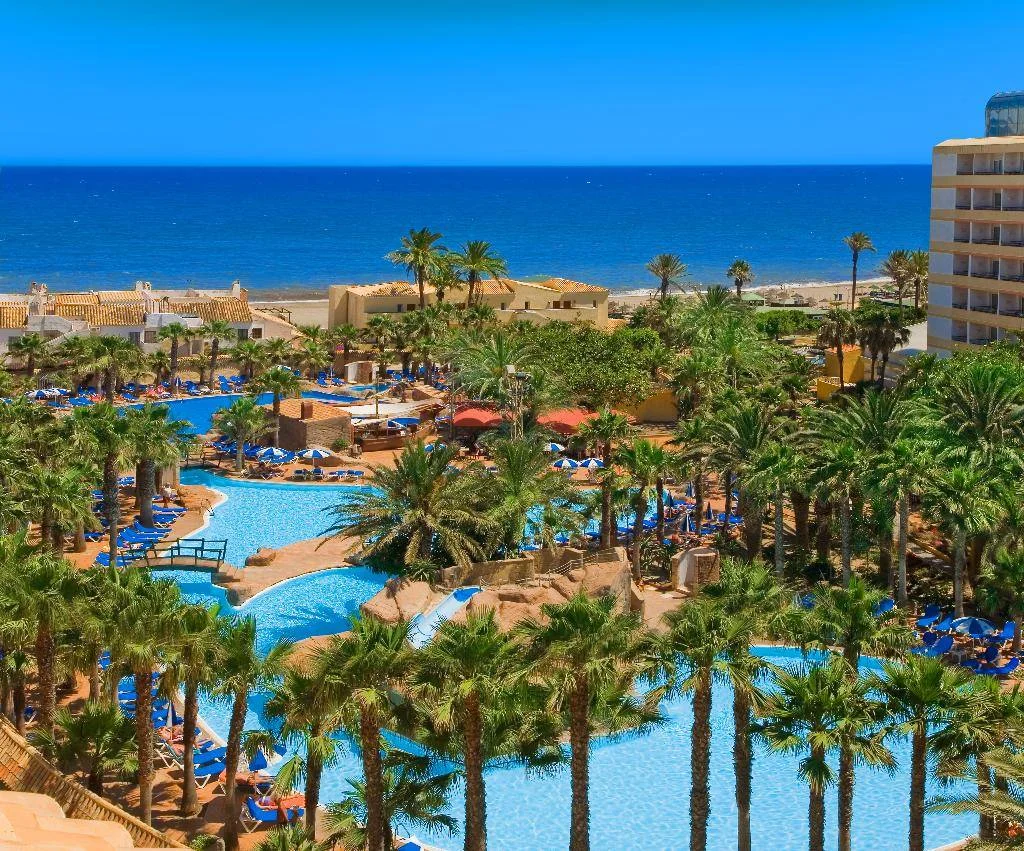 Vista Aérea de las instalaciones del hotel Playasol donde se ve la playa al fondo, las piscinas y todas las palmeras de las zonas verdes