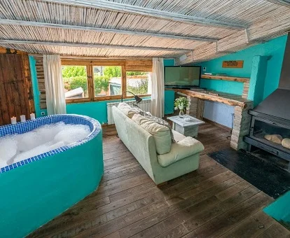 Foto del jacuzzi en mitad de la suite que se encuentra cerca de la ventana y en frente de la chimenea