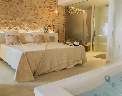 Foto de la bañera de hidromasaje que se encuentra enfrente de la cama de la Habitación Doble Deluxe para disfrutar un fin de semana romántico en Can Solaies.