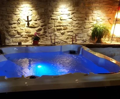 Foto del jacuzzi rectangular de gran tamaño con luces de cromoterapia que se encuentra la casa rural Les Cavallerisses