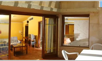Foto de la bañera de hidromasaje de forma circular en un altillo junto a la ventana del bano de la Suite Junior del hotel Eden Binibeca