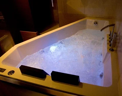 Foto del jacuzzi rectangular y donde caben dos personas cómodamente que se encuentra junto a la cama de la Suite con bañera de hidromasaje del hotel El Gaixero Evolucion.