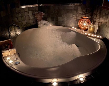 Foto de la bañera de hidromasaje circular llena de espuma que se encuentra en la Suite Junior del Complejo Turístico La Garganta