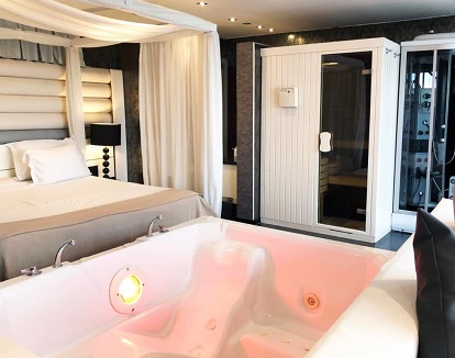 Foto del jacuzzi privado frente a la cama
en la Suite con sauna donde también tienes ducha de hidromasaje y una sauna para relajarte.