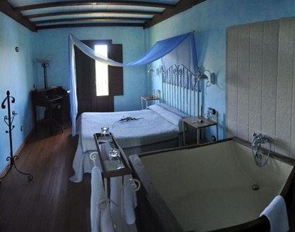 Foto de la bañera junto a la cama de la habitación doble con acceso al spa ideal para una fin de semana de relax.