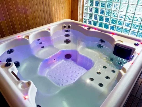 Jacuzzi con chorros de hidromasaje y luces de cromoterapia de los apartamentos rurales El Fresnu
