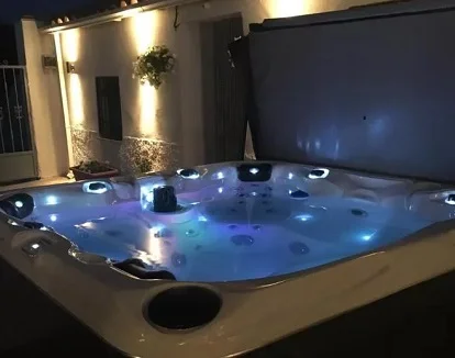 Jacuzzi enorme para cuatro personas con iluminación y cromoterapia que se encuentra en el jardín en el exterior del alojamiento rural Casa Cueva de Ryder Loco