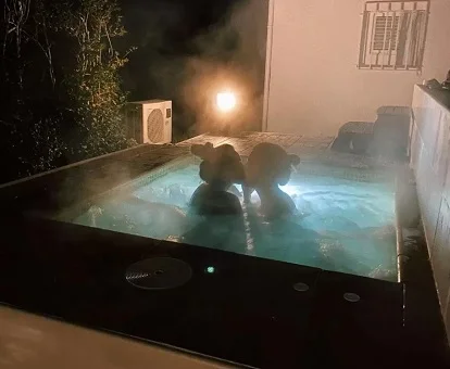 Foto una parejas disfrutando del jacuzzi exterior en la terraza de uno de los bungalows de la casa rural Ca l'Eli different experience