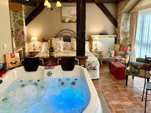 Foto del jacuzzi grande para dos personas que se encuentra frente a la cam en la Suite rústica con bañera de hidromasaje en la Casa Rural La Casa del Puente