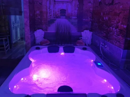 Jacuzzi para dos con cromoterapia y chorros de agua que se encuentra en la Suite Deluxe con bañera de hidromasaje en Apartamentos La Veguilla