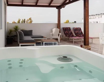 Foto desde el jacuzzi de la terraza cubierta con vistas donde se puede ver al fondo la mesa y los sillones