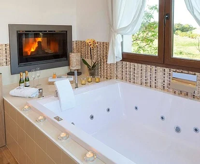 Jacuzzi frente a la chimenea en la Suite Superior del alojamiento rural El Racó de Madremanya