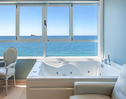 Foto de las vistas a la playa y el mar desde el jacuzzi que se encuentra junto a la ventana en la Habitación Doble con bañera de hidromasaje y vistas al mar del Hotel Villa del Mar