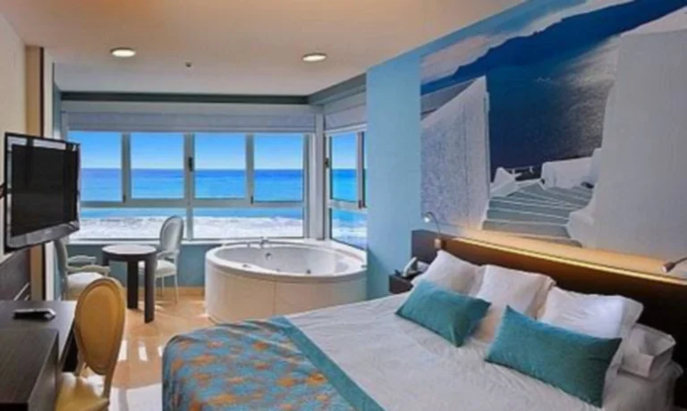 Foto de las vistas a la playa y el mar desde el jacuzzi que se encuentra junto a la ventana en la Habitación Doble con bañera de hidromasaje y vistas al mar del Hotel Villa del Mar