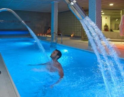 Foto del centro de bienestar con piscina de chorros y jacuzzi.