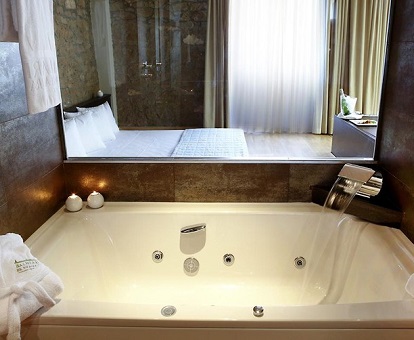 Foto del jacuzzi cerca de la cama en la suite con jacuzzi del Hotel Rural Balneari OCA Rocallaura