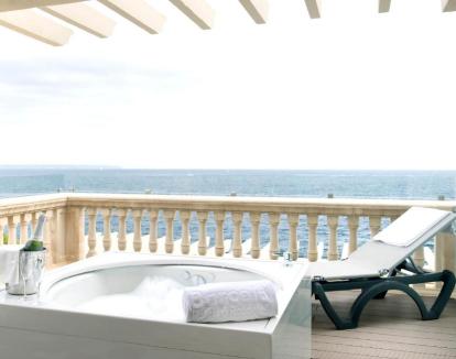 Foto de la Habitación Doble Deluxe con un maravilloso jacuzzi privado en una terraza con vistas al mar.