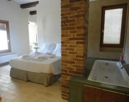 Foto de la acogedora Suite equipada con jacuzzi privado y zona de estar.