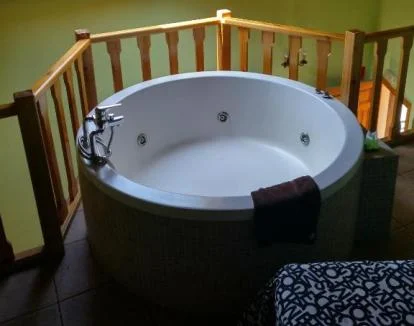 Foto de la casa de un dormitorio con jacuzzi privado junto a la cama y todo lo necesario para una estancia perfecta.