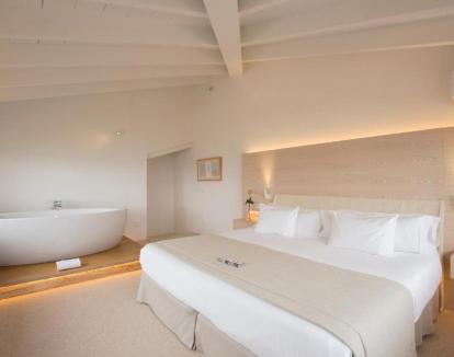 Foto de la Suite Superior con jacuzzi privado junto a la cama y terraza con hermosas vistas.
