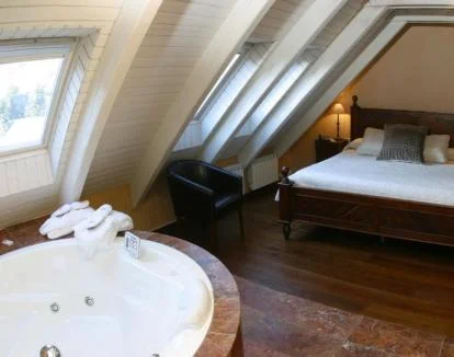 Foto del amplio jacuzzi junto a la cama de la Suite del hotel.