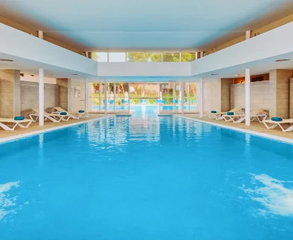 Foto de la piscina cubierta con tumbonas del spa que se encuentra del Blau Colonia Sant Jordi Resort & Spa 

