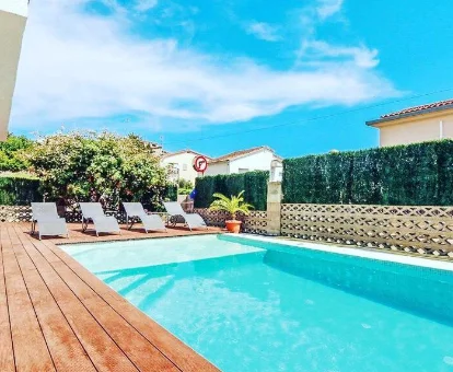 Foto de la piscina con tumbonas que se encuetra en el chalet Can Pinemar 
