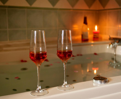 Foto de la bañera de hidromasaje con 2 copas de vino de la Casa Canedo Suite