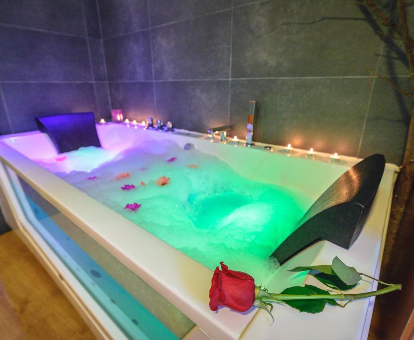 Foto de la bañera de hidromasaje con espuma y pétalos de rosa de la Casa Rural Aguas Frias II