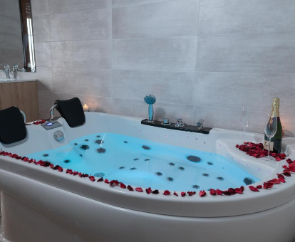 Foto de la bañera de hidromasaje con pétalos de rosa de la Casa Rural Alborelax