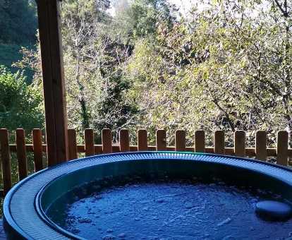 Foto del jacuzzi de exterior con vistas a la arboleda de la casa San Feliz