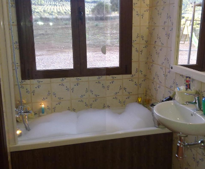 Foto de la bañera de hidromasaje con espuma y vistas de la Casa Rural El Portezuelo
