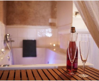 Foto de la bañera de hidromasaje con una copa de champán que se encuentra en la Casa Rural El Simarro