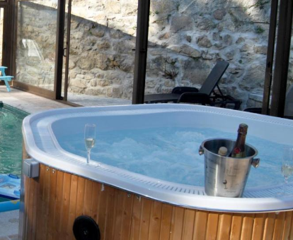 Foto del jacuzzi con copa de champán y piscina privada de la Casa Rural Villa Angeles con Piscina y Jacuzzi 